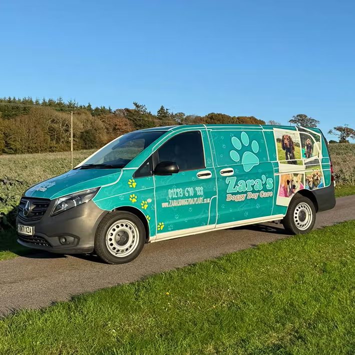 Zara's Doggy Day Care chauffeur van with branded teal livery and happy dog photos