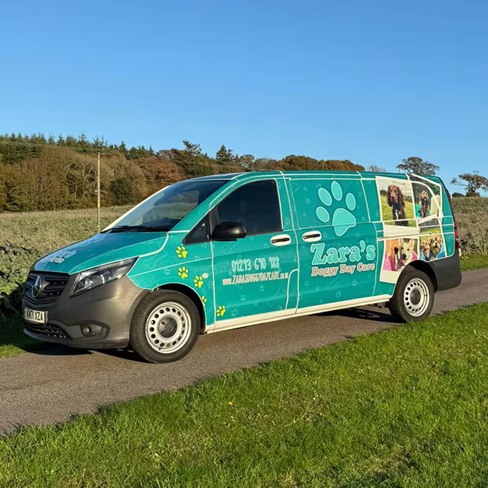 Zara's Doggy Day Care chauffeur van with branded teal livery and happy dog photos